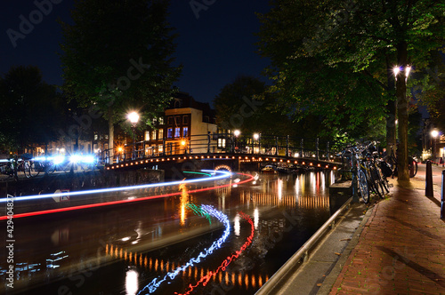 A night in Amsterdam. Light streaks of a boat flowing down the canal. Summer. Night.