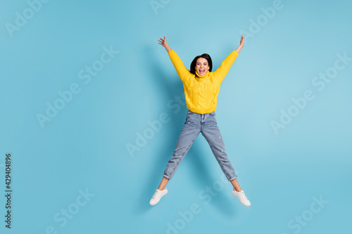 Full length bdoy size view of attractive cheerful girl jumping having fun freedom isolated over bright blue color background