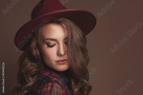 Portrait of young beautiful woman in fedora hat