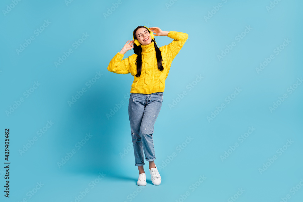 Full length bdoy size view of attractive cheerful dreamy girl enjoying listening music isolated over bright blue color background Full length bdoy size view of attractive cheerful dreamy girl enjoying listening music isolated over bright blue color background