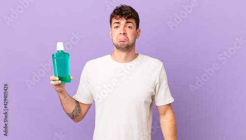 man with mouthwash feeling sad and whiney with an unhappy look, crying with a negative and frustrated attitude photo