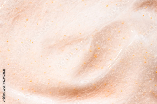 The texture of a scrub or shower gel on a beige background.