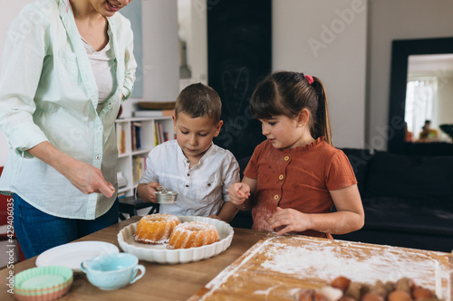 kids and mother eating cake at home