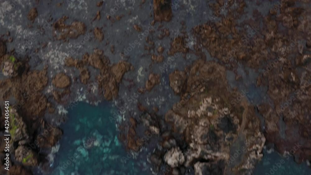 Fast flight over the surface of the water and stones visible from it.. Rocky shore of the island of Tenerife. Aerial drone footage of sea waves reaching shore Fast flight over the surface of the water and stones visible from it.. Rocky shore of the island of Tenerife. Aerial drone footage of sea waves reaching shore