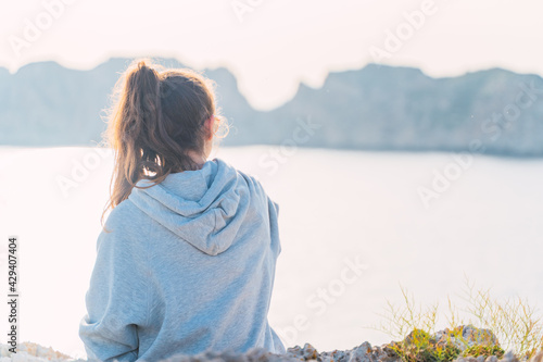 Caucasian woman enjoying the views of a cliff by the sea at the Malgrats Islands in Santa Ponça. Palma de Mallorca, Spain photo