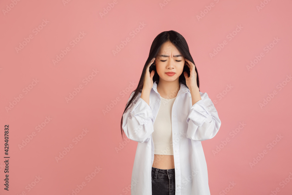 Asian young woman's portrait on pink studio background. Concept of human emotions, facial expression, youth, sales, ad. Asian young woman's portrait on pink studio background. Concept of human emotions, facial expression, youth, sales, ad.