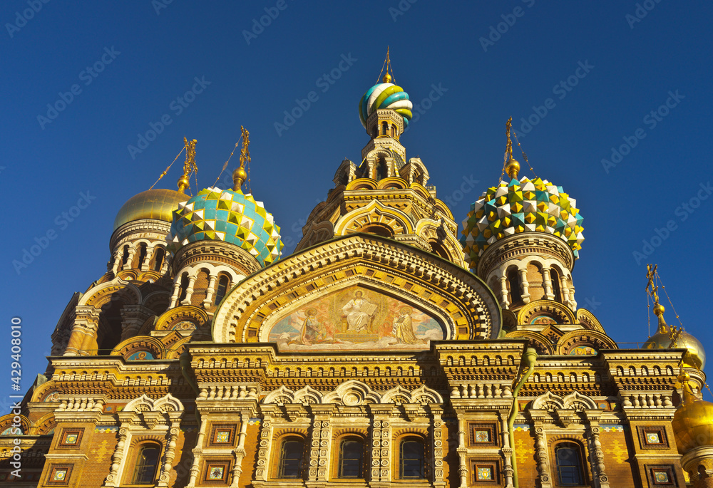 St. Petersburg. Domes of Church of Savior on Spilled Blood against the background of blue sky. Icon on the facade and details of the richly decorated Cathedral of the Resurrection of Christ, exterior