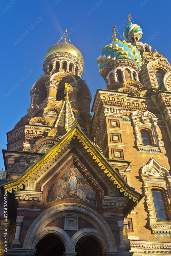 St. Petersburg. Domes of Church of Savior on Spilled Blood (Spas na Krovi) against  blue sky and icon above entrance to Cathedral of Resurrection of Christ. Beautiful exterior in old Russian style