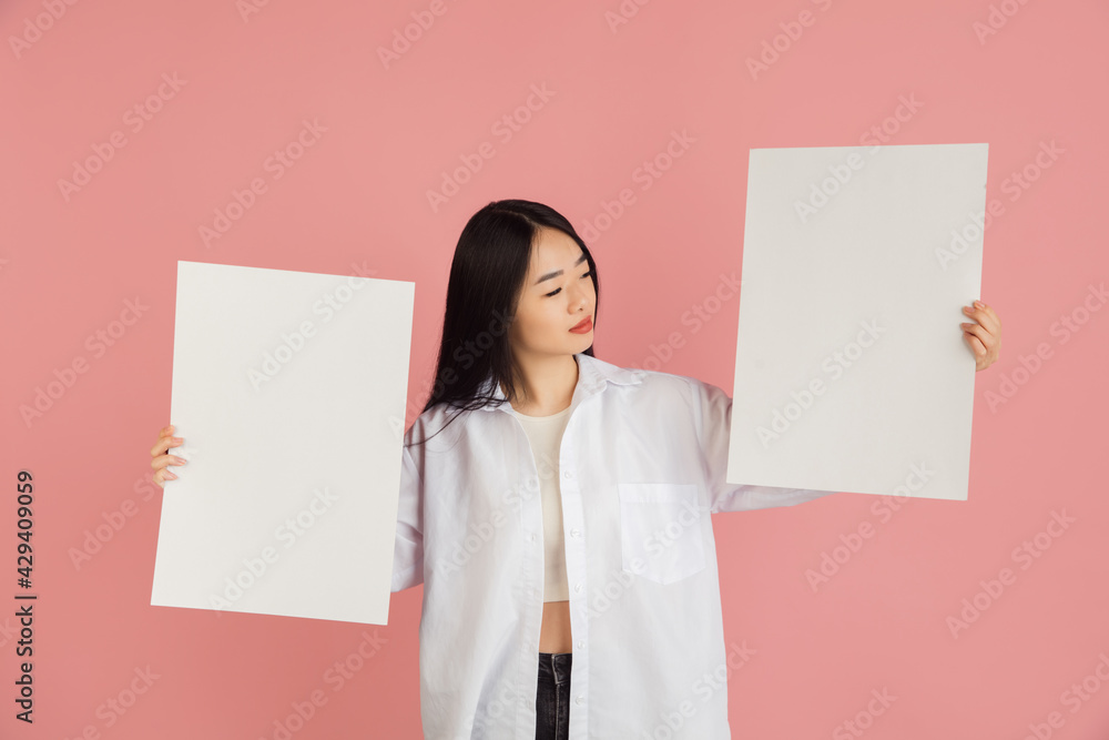 Asian young woman's portrait on pink studio background. Concept of human emotions, facial expression, youth, sales, ad. Asian young woman's portrait on pink studio background. Concept of human emotions, facial expression, youth, sales, ad.
