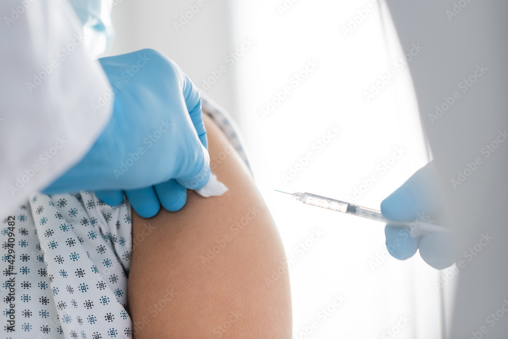 partial view of doctor in latex gloves doing vaccine injection to patient partial view of doctor in latex gloves doing vaccine injection to patient