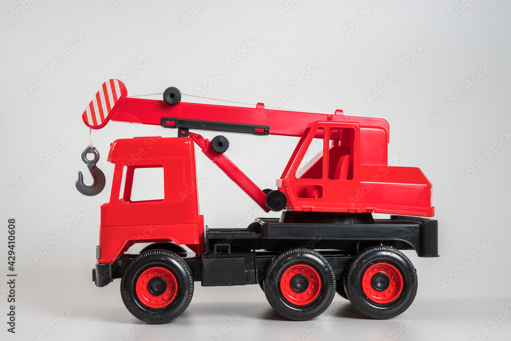 Fototapeta premium Multi-colored plastic children's toy cars on a white background. Red truck crane.