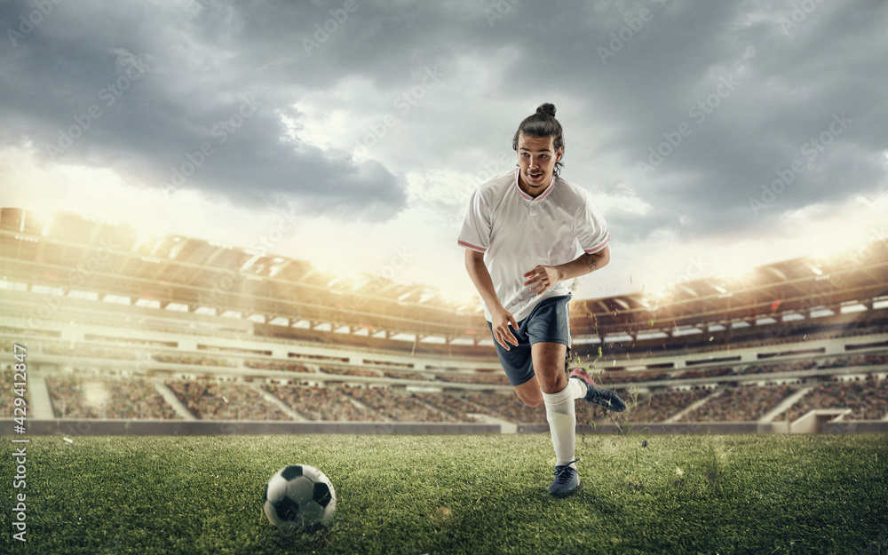 Male soccer, football player catching ball in jump at the stadium during  sport match on dark sky background Stock Photo | Adobe Stock