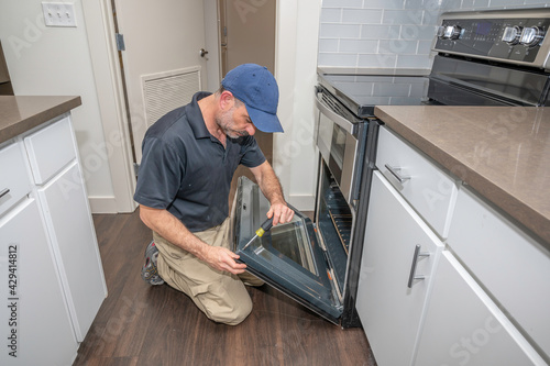 Appliance technician working on an oven door
