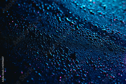 rainfall and moisture over a metal surface at night. cyber colours  defocused background  bokeh effect  wallpaper.