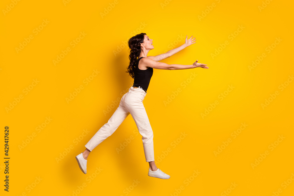 Full length body size side profile photo of woman jumping up opened hands missing someone isolated vivid yellow color background