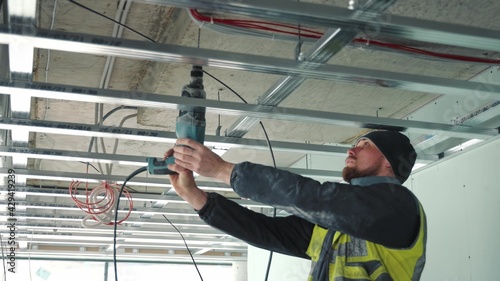 A master who drills a hole in the ceiling with a drill. Creation of false ceilings.