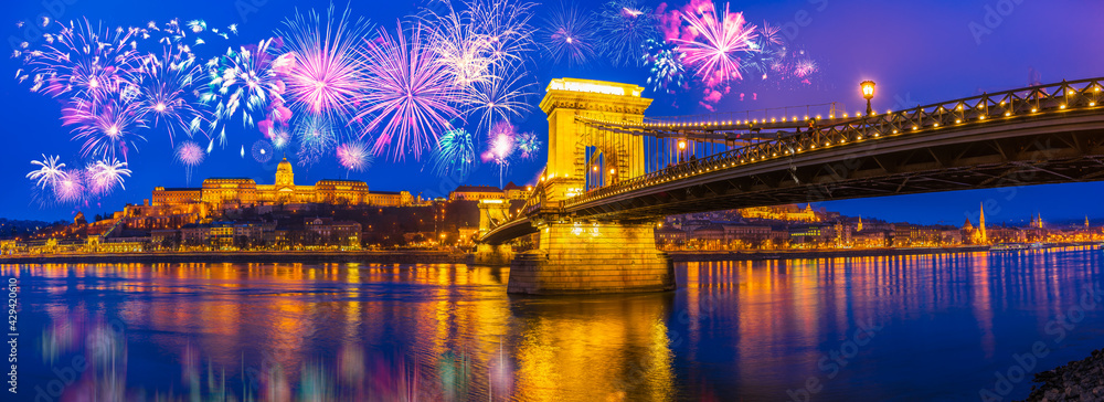 Fototapeta premium Fireworks display at the Royal palace of Buda and the Chain Bridge in Budapest, New Year Eve panorama 