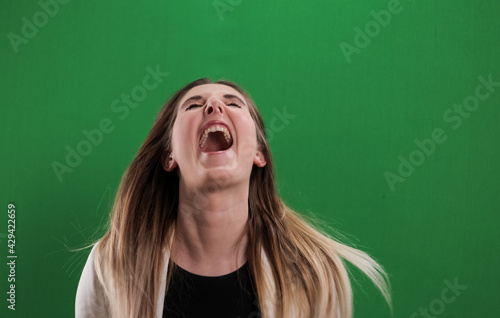 Young woman laughs very loudly - studio photography