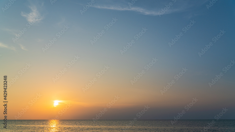 sunset sky over the sea in the evening with colorful orange sunlight 