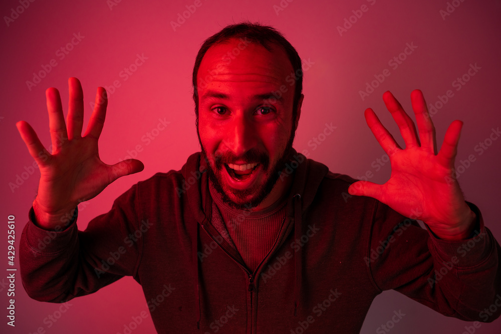 concept af angry and abusive man with red light. studio portrait of young furious man exploding with anger concept af angry and abusive man with red light. studio portrait of young furious man exploding with anger