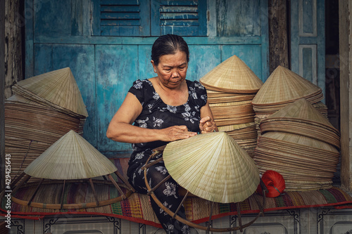 Fotografija Vietnamese Old woman craftsman making the traditional vietnam hat in the old tra