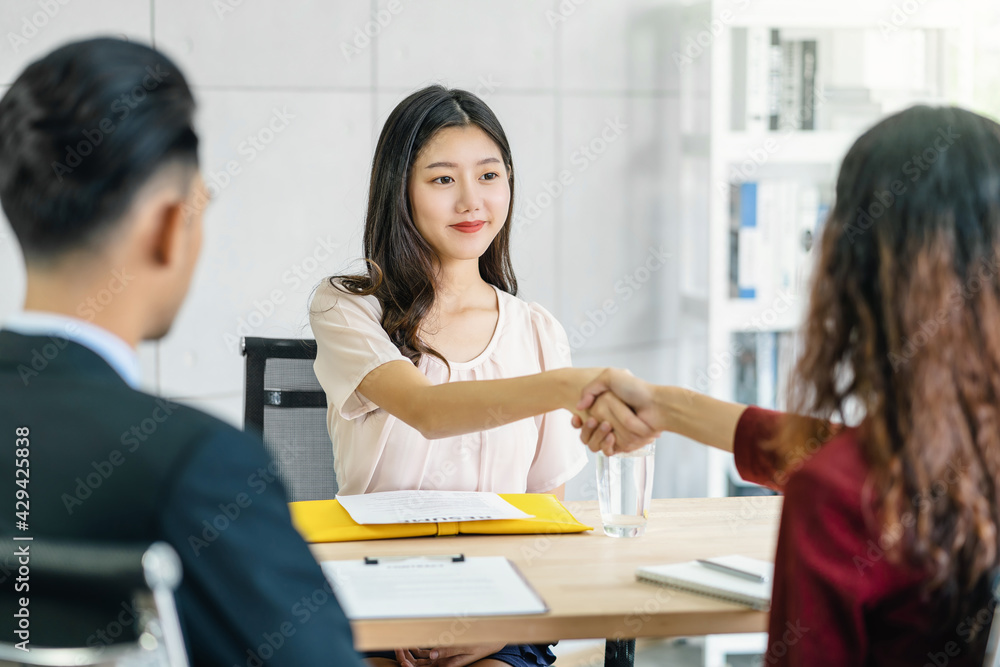 Young Asian woman graduate hand shake with two manager to welcome before start to job interview with positive motion in meeting room,Business Hiring new member,Job interview first impressions concept Young Asian woman graduate hand shake with two manager to welcome before start to job interview with positive motion in meeting room,Business Hiring new member,Job interview first impressions concept