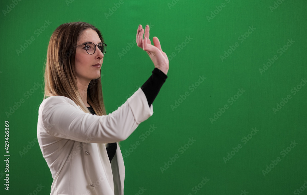 Young woman taps on a large imaginary touchscreen - studio photography Young woman taps on a large imaginary touchscreen - studio photography