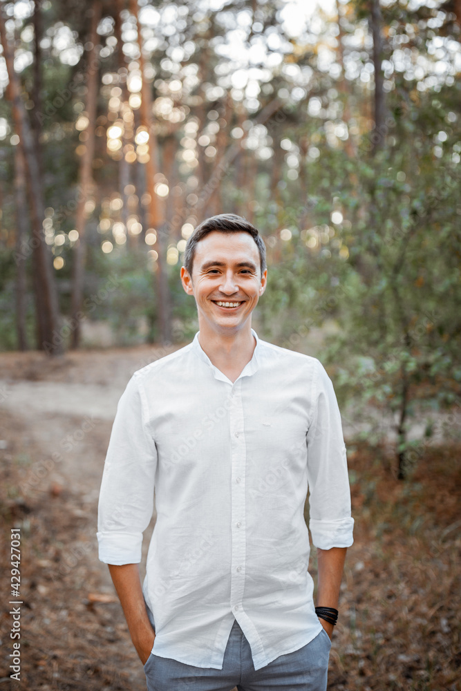 Happy young groom laughing at sunset in the forest. Happy young groom laughing at sunset in the forest.