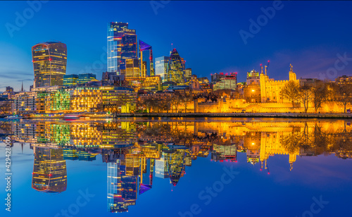 Tower of London and financial district of London reflected at dusk