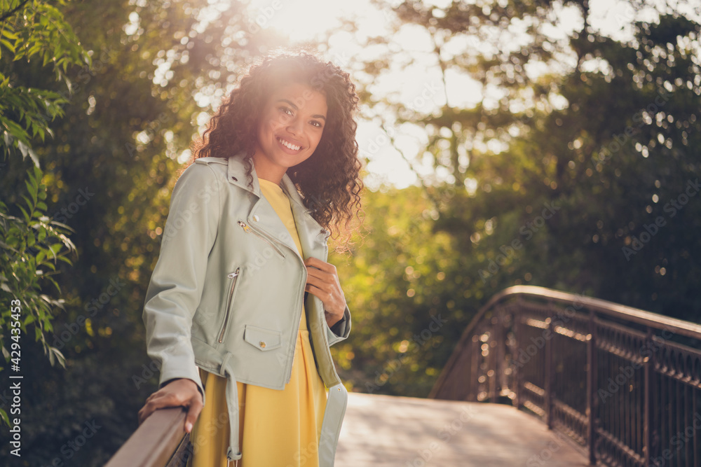 Photo of charming pretty lady stand bridge look camera wear yellow dress jacket in green park outside Photo of charming pretty lady stand bridge look camera wear yellow dress jacket in green park outside