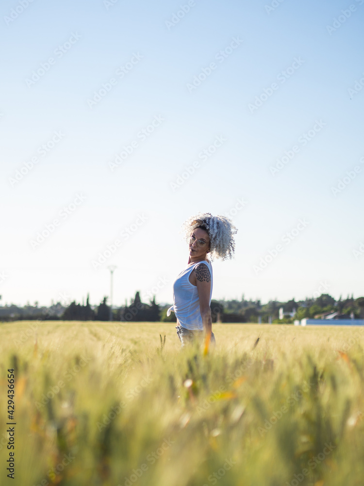 Mujer joven con pelo blanco en un campo de trigo Mujer joven con pelo blanco en un campo de trigo