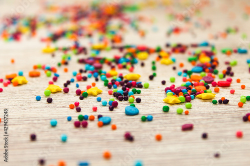 Sugar sprinkled on a white wooden background. Bright colors and sweet taste. Sprinkle for Easter icing. Preparing for Easter