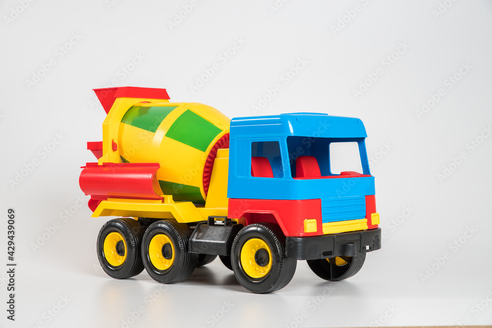 Multi-colored plastic children's toy cars on a white background. Concrete truck. Multi-colored plastic children's toy cars on a white background. Concrete truck.