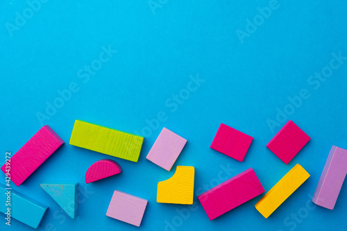 Multicolored pieces of toy constructor on blue background