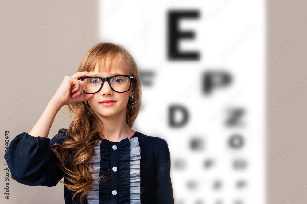 Checking the vision of a child of an 8-9 year-old girl with an ophthalmologist. School, games spoil children's vision. Myopia. Checking the vision of a child of an 8-9 year-old girl with an ophthalmologist. School, games spoil children's vision. Myopia.