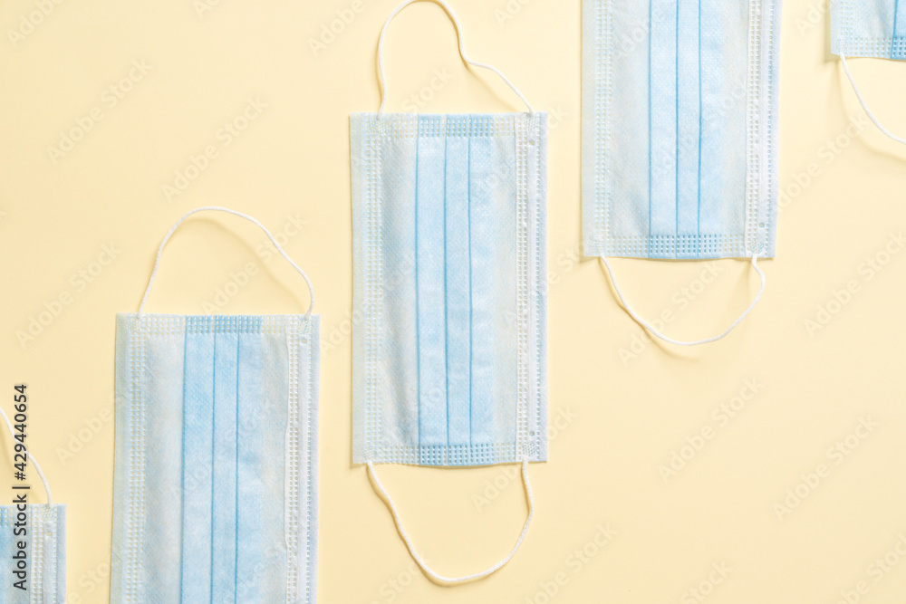 The overhead view of the disposable protective masks lying on a beige background The overhead view of the disposable protective masks lying on a beige background