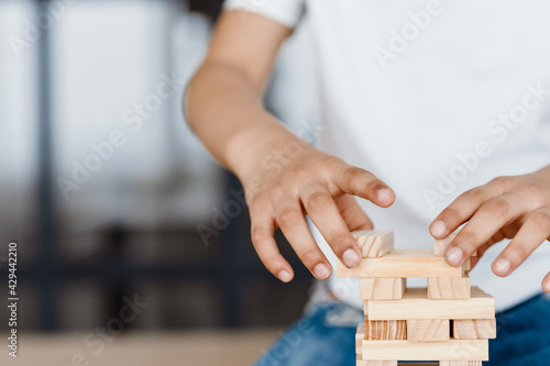 Cropped photo of boy playing with wooden planks at home