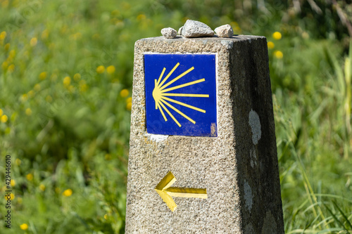 фотографія Camino de Santiago sign on stone monolith with green grass background