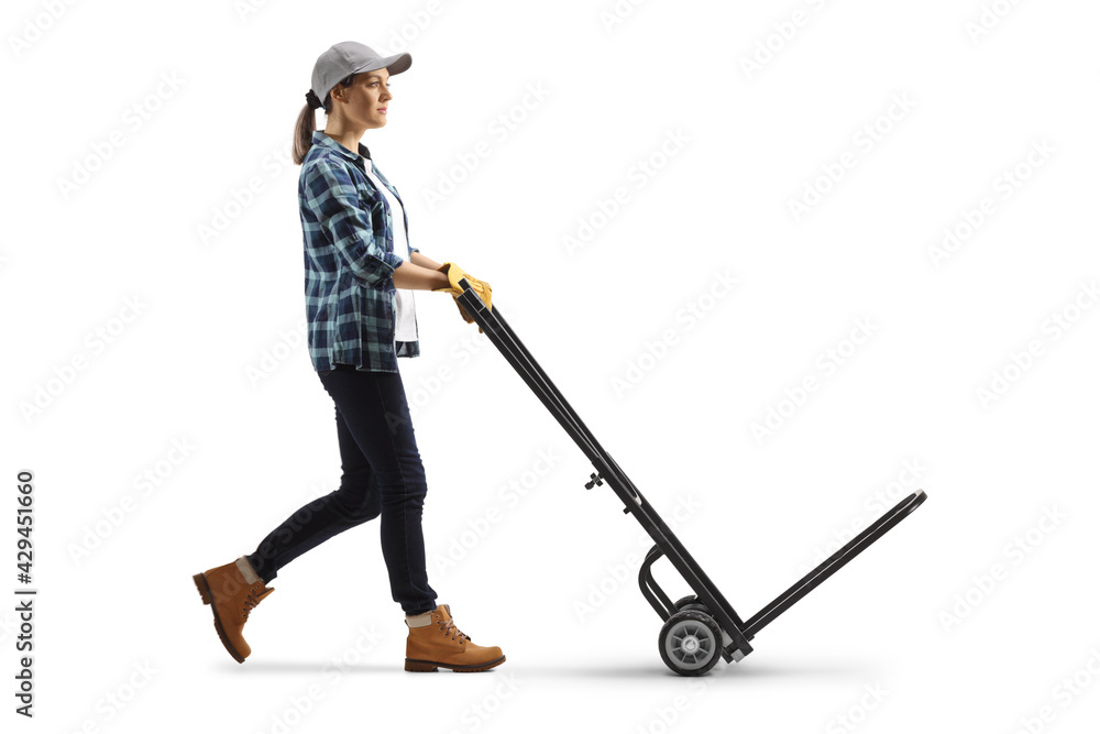 Full length profile shot of a female worker pushing an empty hand truck Full length profile shot of a female worker pushing an empty hand truck