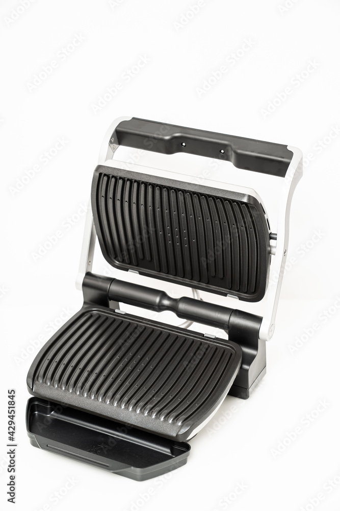 electric grill with open lid. appliance for cooking in everyday life. Made of stainless steel, special non-stick coating. healthy food. food without oil and fat. electric grill with open lid. appliance for cooking in everyday life. Made of stainless steel, special non-stick coating. healthy food. food without oil and fat.