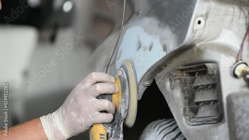 auto repairman grinding autobody bonnet photo