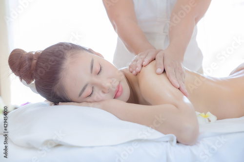 A beautiful Asian woman is comfortably relaxed in a spa shop after the masseuse has massaged her body