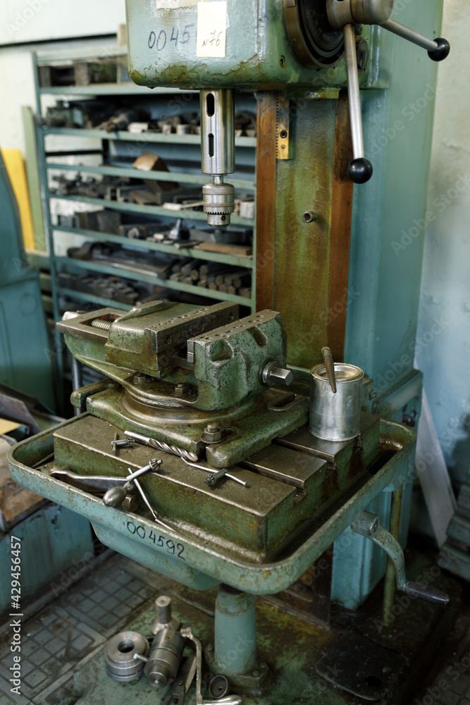 Drilling machine in the old shop. Drilling machine parts and spindle with drills.
