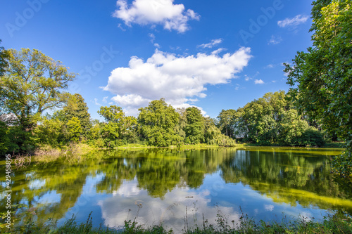Großer Teich mit blauem Himmel und weißen Wolken im Sommer