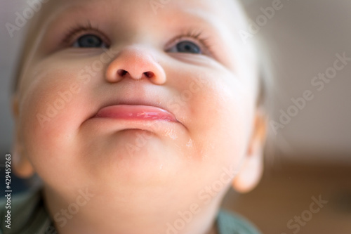 Looking up at the face of cute chubby toddler  bottom lip pushed out and eyes looking skyward