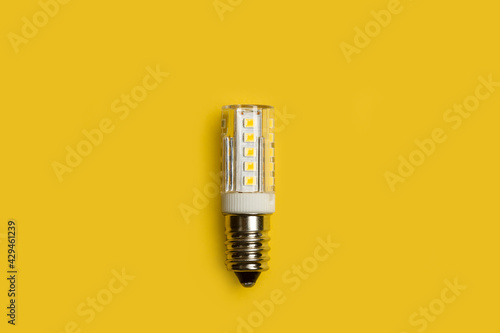 Bombilla de luz led sobre un fondo amarillo liso y aislado. Vista superior y de cerca. Copy space photo
