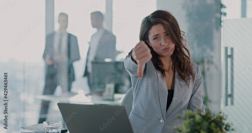 Portrait of hiring manager woman showing thumbs down to camera refusing job application candidate posing at camera. HR manager. Corporate people.