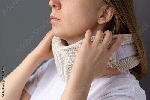 The girl puts on a supportive collar for the neck. Medical corset for fixing the neck.