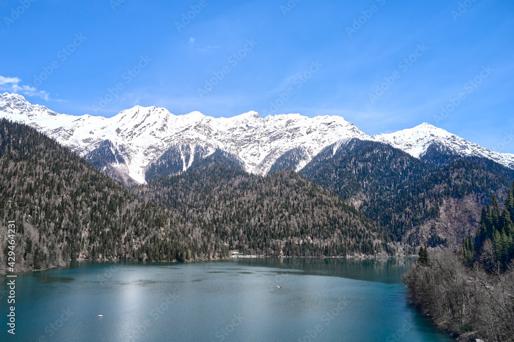 A picturesque lake surrounded by snow-capped mountains. Shooting from a drone. Copy space.