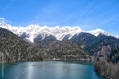 A picturesque lake surrounded by snow-capped mountains. Shooting from a drone. Copy space.